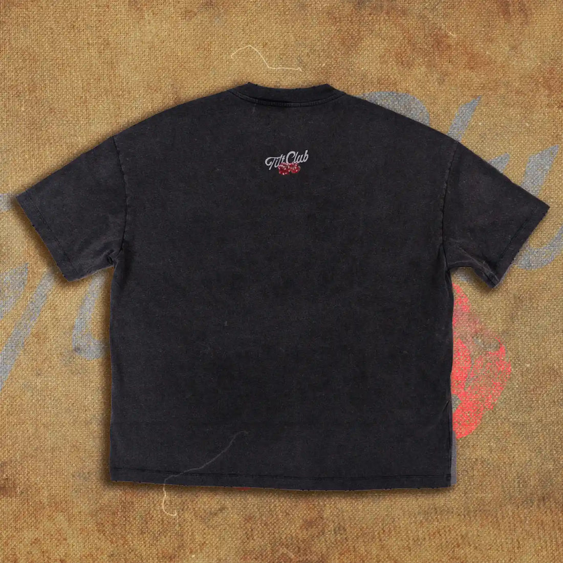 Black t-shirt featuring a graphic design of a monkey wearing sunglasses and a crown, surrounded by dice, playing cards, and a Vegas-style 'Welcome to Tilt Club' sign.