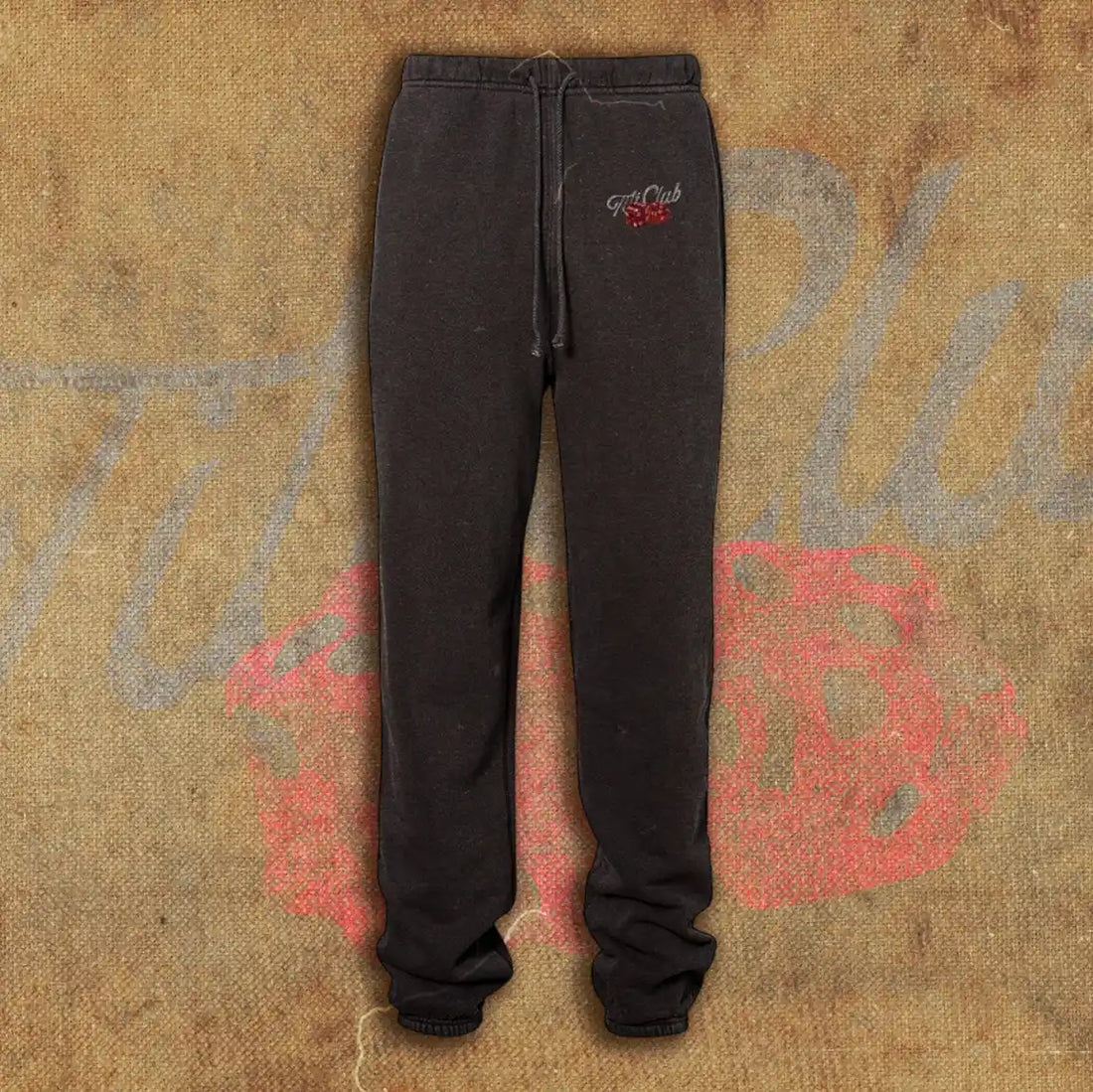 Black sweatpants featuring a minimalist design with the 'Tilt Club' logo embroidered near the waistband, complete with a drawstring closure and relaxed fit.
